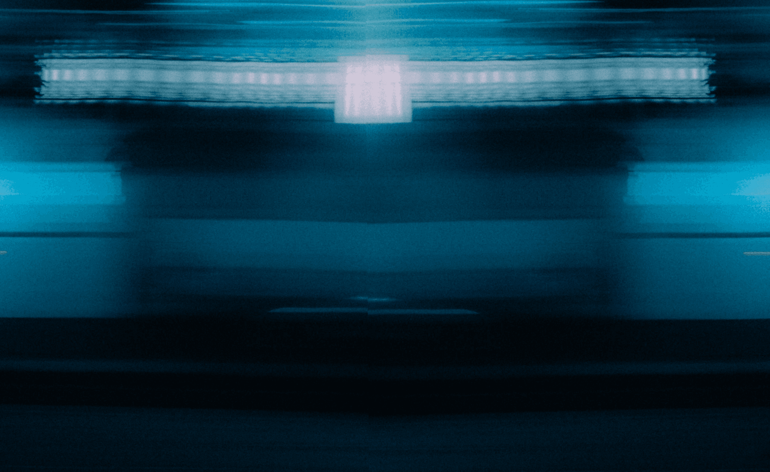 Blurry silhouette of a person riding a scooter at night